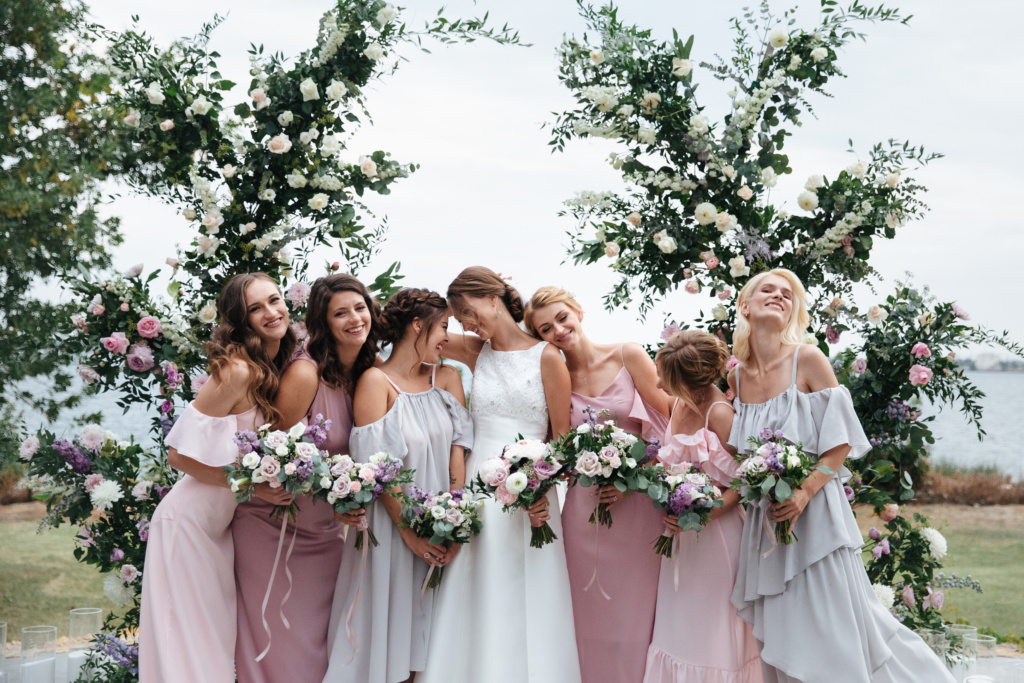 smiling bridesmaids in delicate pink beige summer dress on the wedding ceremony